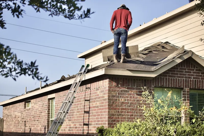 Professional roofer working on a residential roof in Hermitage Park